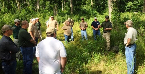 Private Lands Biologist gives a presentation in the woods