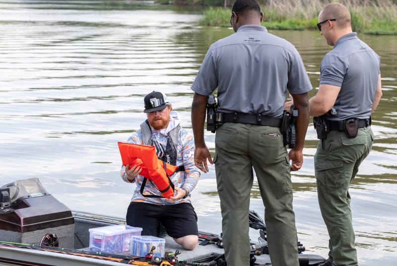 Officers inspecting safety supplies of a boater
